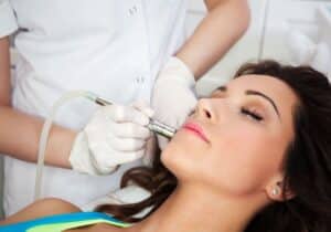 A woman at the dermatologist receiving professional treatment for her acne scars, aiming for smoother, clearer skin