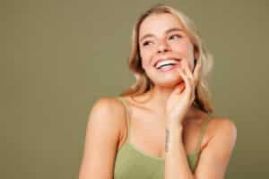 Close-up of young woman with slim body and smooth skin wearing lingerie, smiling and touching face, symbolizing beauty, fitness, and healthy lifestyle